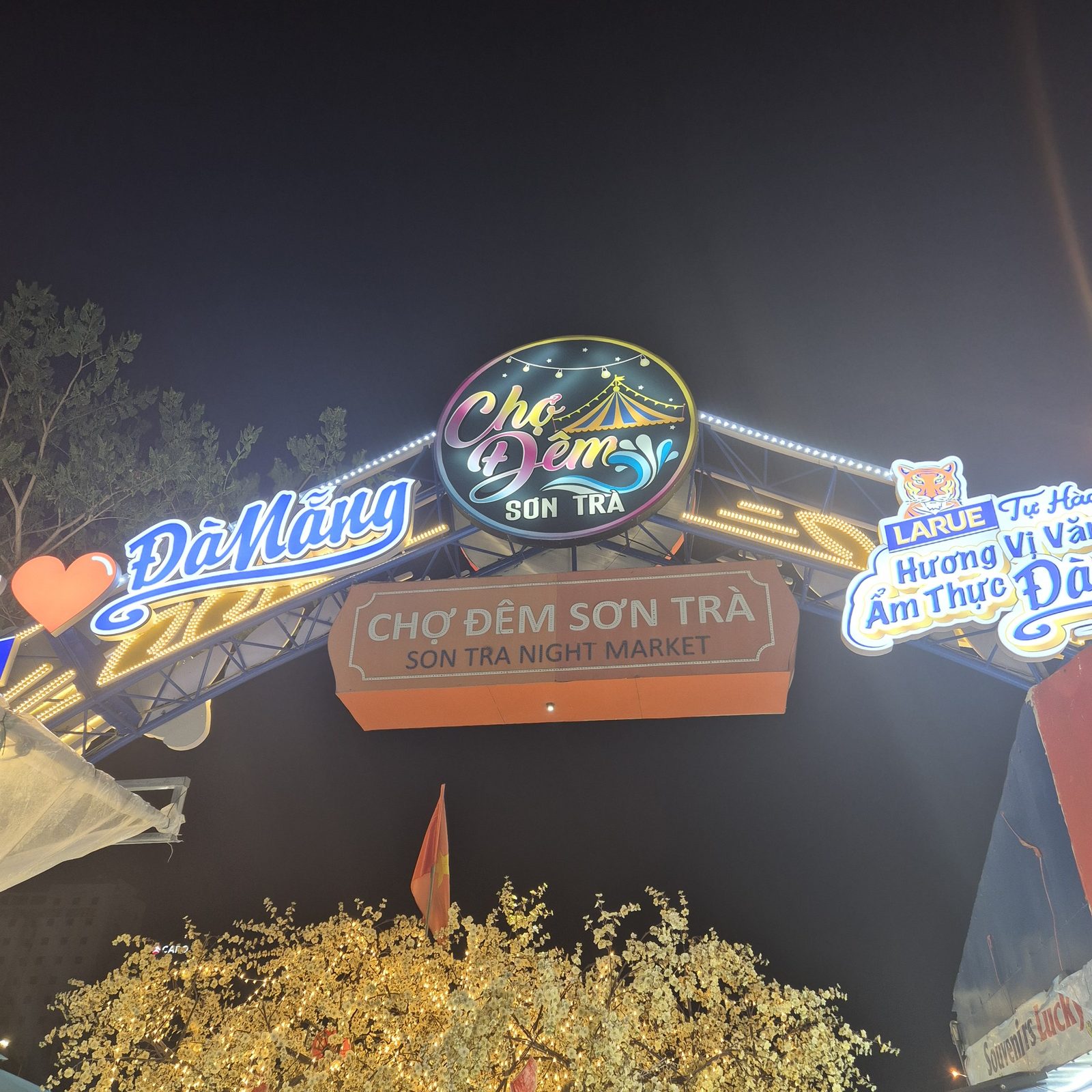 손짜 야시장 입구 아치. CHỢ ĐÊM SƠN TRÀ / SON TRA NIGHT MARKET 간판과 전구·라루에 광고